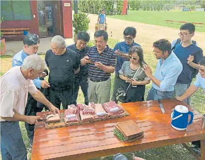 ?? STRIN AGRO ?? De calidad. Roberto Guercetti, a la izquierda, muestra al grupo de chinos los diferentes cortes de carne.