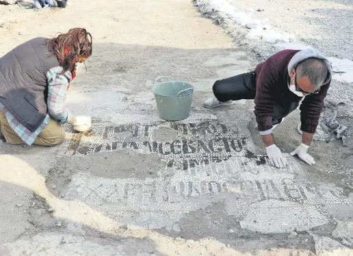  ??  ?? Two archaeolog­ists uncover mosaics at the excavation of the Monastery of St. Simeon Stylites the Younger in Hatay, southern Turkey, Nov. 26, 2020.