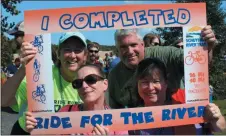  ?? MICHILEA PATTERSON – FOR MEDIANEWS GROUP ?? A group of people pose for a photo with a “I Completed Ride for the River” selfie frame. The annual bike ride begins in Pottstown and includes a 16-mile and 35-mile option.