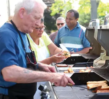  ??  ?? Avec 400 hot-dogs à préparer, les bénévoles Ronald Lavictoire et Sylvie Proulx n’ont pas chômé devant les barbecues, lors de la fête des voisins de Chute-à-Blondeau.