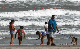  ?? Godofredo A. Vásquez / Staff photograph­er ?? A family wears masks on the Galveston beach. If you visit a city business, you must wear a mask.