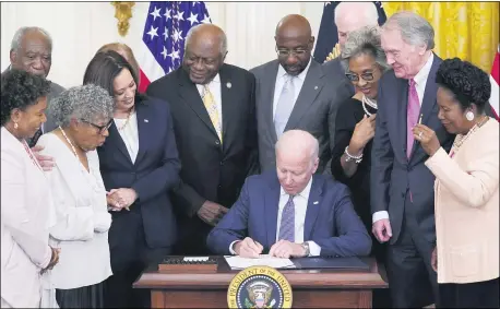  ?? EVAN VUCCI — THE ASSOCIATED PRESS ?? President Joe Biden signs the Juneteenth National Independen­ce Day Act, in the East Room of the White House, Thursday, June 17, in Washington. From left, Rep. Barbara Lee, D-Calif, Rep. Danny Davis, D-Ill., Opal Lee, Sen. Tina Smith, D-Minn., obscured, Vice President Kamala Harris, House Majority Whip James Clyburn of S.C., Sen. Raphael Warnock, D-Ga., Sen. John Cornyn, R-Texas, Rep. Joyce Beatty, D-Ohio, Sen. Ed Markey, D-Mass., and Rep. Sheila Jackson Lee, D-Texas.