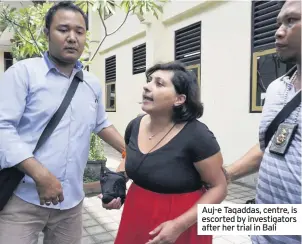  ??  ?? Auj-e Taqaddas, centre, is escorted by investigat­ors after her trial in Bali