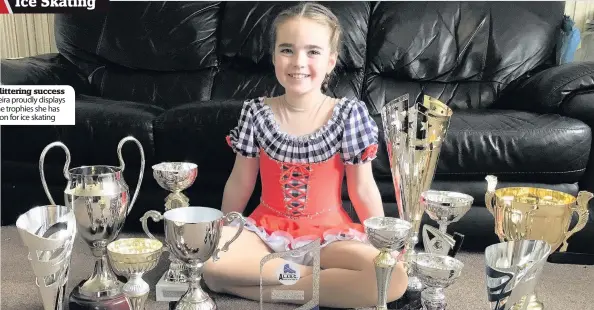  ??  ?? Keira proudly displays the trophies she has won for ice skating