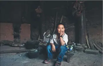  ??  ?? A Yongzhi, 13, a boy in the photograph­y class, impresses both teachers and classmates with his laughter and peoplefocu­sed photos.