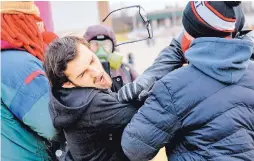  ?? LANSING STATE JOURNAL/ASSOCIATED PRESS ?? A man who was trying to enter an event to hear white nationalis­t Richard Spencer speak is punched in the face by a protester Monday at Michigan State University in East Lansing, Mich.