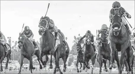  ?? Benoit Photo ?? “IT WAS a really good day,” Santa Anita’s top executive said. Mo Forza, right, wins the Mathis Brothers Mile with jockey Joel Rosario.