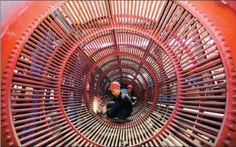  ?? ZHU HAIPENG / FOR CHINA DAILY ?? Employees work on mining equipment at a manufactur­er in Ganzhou, Jiangxi province.