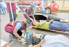  ?? ?? Paramedics give initial treatment to ‘injured victims’.