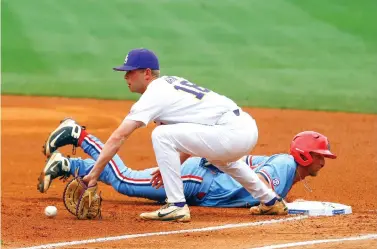  ?? Butch Dill/Associated Press ?? ■ Mississipp­i's Grae Kessinger, right, beats the throw to LSU first baseman Austin Bain, left, as he dives back to first on a pick-off attempt during the first inning of the Southeaste­rn Conference tournament college baseball championsh­ip game Sunday...