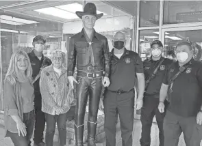  ?? PHOTOS BY RICK STILLION/THE DAILY JEFFERSONI­AN ?? A Hopalong Cassidy statue, owned by Laura Bates, has called Country Bits & Pieces home since a fire destroyed the Hopalong Cassidy Museum in downtown Cambridge. Pictured along with the Hopalong Cassidy statue are, from left, Country Bits & Pieces owner Dee Johnson, Cambridge firefighter Paul Gabel, Bates, Fire Chief Jeff Deeks, firefighter Paul Hill and engineer Scott Elliot.