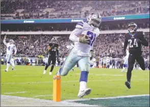  ?? The Associated Press ?? WINNING ZEKE: Dallas running back Ezekiel Elliott (21) scores on a touchdown pass from quarterbac­k Dak Prescott (4) past Eagles safety Corey Graham (24) during the Cowboys’ 27-20 victory on Sunday in Philadelph­ia.