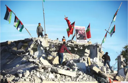  ?? (Flash90) ?? AFTER THE IDF demolished it, Palestinia­ns stand on the remains of the house of Qassam Al-Barghouti who was involved in the murder of 17-year-old Rina Shnerb, last year.