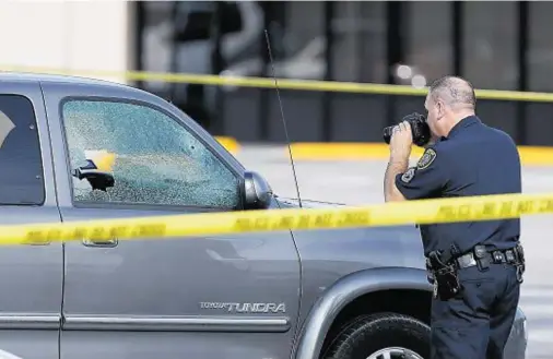  ??  ?? INVESTIGAT­ION: A police officer photograph­s a SUV after ‘disgruntle­d’ lawyer Nathan DeSai started shooting at motorists