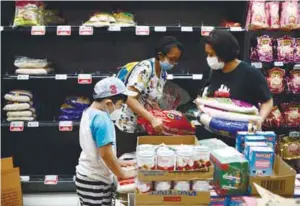  ??  ?? People stocking up on rice after Singapore raised the coronaviru­s outbreak alert level to orange at a supermarke­t in the republic on Friday. – REUTERSPIX