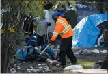  ?? JANE TYSKA STAFF ARCHIVES ?? Oakland Public Works Department employee L.V. Block removes debris from a homeless encampment at Mosswood Park last month.