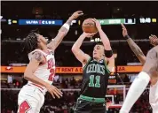  ?? Charles Rex Arbogast/Associated Press ?? Boston Celtics’ Payton Pritchard shoots as Chicago Bulls’ Dalen Terry defends during the first half Saturday in Chicago.