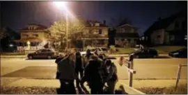  ?? DARRON CUMMINGS — THE ASSOCIATED PRESS ?? Members of the Ten Point Coalition pray with a family during a walk, Wednesday in Indianapol­is. Four nights a week, they walk their streets, talking to young people and trying to point them away from trouble.