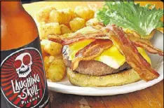  ?? AJC FILE PHOTO ?? The Vortex Classic Coronary burger with Tater Tots and a Laughing Skull beer.