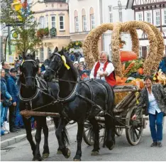  ??  ?? Barbara Kempfle bremste das dynamische Gespann von Fritz Deutschenb­auer mit dem festlich dekorierte­n Erntewagen und der Getreidekr­one in der Marktstraß­e.