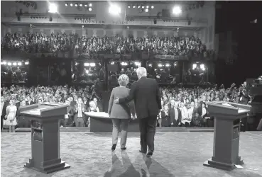  ??  ?? Democratic presidenti­al nominee Hillary Clinton and Republican presidenti­al nominee Donald Trump walk across the stage after the presidenti­al debate Monday at Hofstra University in Hempstead, N.Y.