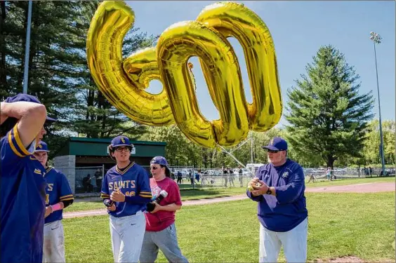  ?? Photos by Jim Franco / Times Union ?? Saratoga Central Catholic coach Phonsey Lambert holds balloons marking his 600th career victory after his team beat Schuylervi­lle in the Phil Waring Memorial Tournament title game on Saturday. Lambert is 600-213 in his time with the Saints, with five Section II titles.