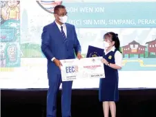  ?? — Bernama photo ?? Takiyuddin awards Goh Wen Xing, 10, for winning the Energy Efficiency Challenge 2021 Poster Challenge for the 7-10 age group.