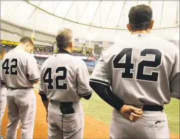  ?? Chris O’Meara / AP ?? Members of the New York Yankees wear No. 42 in honor of Jackie Robinson during the National Anthem before an MLB game against the Tampa Bay Rays on April 15, 2009 in St. Petersburg, Fla.