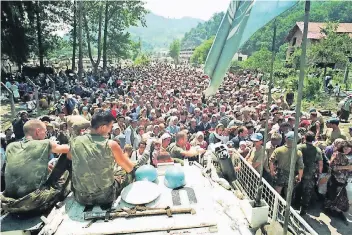  ?? FOTO: AP ?? Niederländ­ische Blauhelmso­ldaten empfangen am 13. Juli 1995 in Potocari Hunderte von muslimisch­en Zivilisten, die aus dem nahegelege­nen Srebrenica vor serbischem Terror geflüchtet sind.