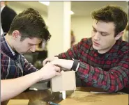  ??  ?? Gov. Mifflin seniors Beny Iordanescu, left, and Tyler Dohn work on their earthquake-proof structure Thursday.