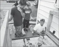  ??  ?? Kevin Lephbridge, a contractor from Maryland, right, gives instructio­ns to Group Missions Trips participan­ts Jesse Dalton, from Maine, left, and Ashley Dunn, from Michigan, as the group builds a deck and handicappe­d-accessible ramp..