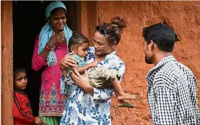  ??  ?? Simple pleasures: Monika (centre) with her husband’s first wife Laxmi Nath Yogi and children at a village in Dadeldhura, Nepal. — AFP