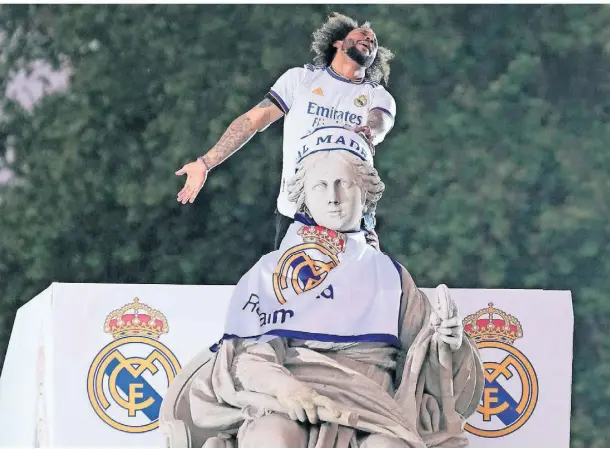  ?? FOTO: PAUL WHITE/AP ?? Losgelöst: Real Madrids Kapitän Marcelo feiert oben auf dem Cibeles-Brunnen den Meistertit­el.