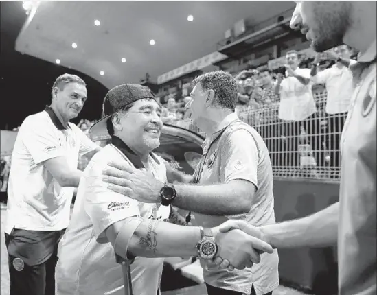  ?? Gary Coronado Los Angeles Times ?? DIEGO MARADONA, second from left, coach of the second-division Dorados of Sinaloa, greets opposing coaches before the start of a recent game in Culiacan.