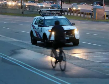  ?? STEVE RUSSELL/TORONTO STAR ?? A cyclist rides past the spot where a 5-year-old was killed after falling off the bike path. The driver of the vehicle remained at the scene.