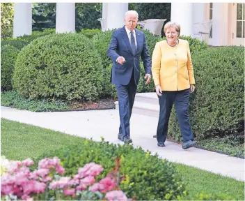  ?? FOTO: BERGMANN/DPA ?? Kanzlerin Angela Merkel und Präsident Joe Biden auf dem Weg zur Pressekonf­erenz im Weißen Haus.