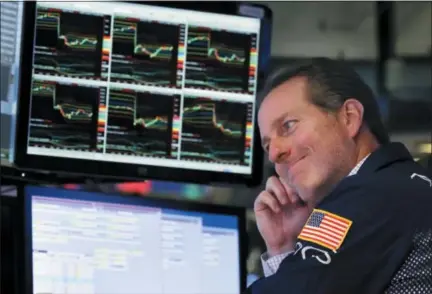  ?? AP PHOTO/RICHARD DREW, FILE ?? Specialist Glenn Carell works at his post on the floor of the New York Stock Exchange on Oct. 23. More than any other group, companies themselves are the largest purchasers of their own shares. But they were notably absent from the market the last few weeks, just as stock prices were tumbling on worries about global trade and rising interest rates.