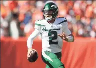  ?? Matthew Stockman / Getty Images ?? Jets QB Zach Wilson scrambles against the Broncos on Sunday in Denver.