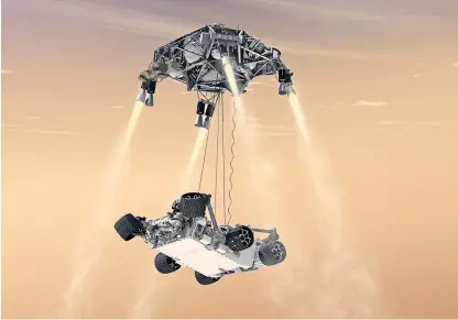  ??  ?? An artist’s impression of the rover being lowered on to Mars using cables.
