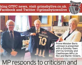  ??  ?? Prime Minister Boris Johnson is presented with a Grimsby Town shirt by Grimsby and Cleethorpe­s MPs Lia Nici and Martin Vickers.