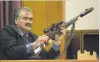  ?? PHOTO: ODT FILES ?? Controvers­ial . . . Robert Ngamoki, a police armourer, with the Winchester rifle used in the Bain murders, during the retrial of David Bain.