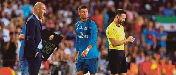  ?? REUTERS PIC ?? A dejected Cristiano Ronaldo (centre) walks towards Real Madrid coach Zinedine Zidane after being sent off during the Spanish Super Cup first leg match against Barcelona on Sunday.