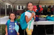 ?? CLAIRE SAVAGE — THE ASSOCIATED PRESS ?? Sisters Audrey, left, and Jubilee Colon pick out new backpacks at a Chicago Public Schools back-to-school supply giveaway recently.