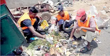  ??  ?? Behind the Premadasa stadium, garbage being segregated by workers belonging to a private waste disposal company.