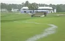  ?? GETTY IMAGES ?? A stream of rainwater runs down the 18th fairway at Aronimink Golf Club during a delay Sunday before the final round of the BMW Championsh­ip was postponed.