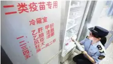  ??  ?? A local market supervisor­y authority official checks on vaccines at a hospital in Rongan in China’s southern Guangxi region. — AFP