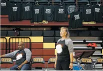  ?? LUIS SÁNCHEZ SATURNO/THE NEW MEXICAN ?? Las Vegas Robertson interim head coach Fran Jenkins stands on the sideline during a game with shirts supporting the head coach hanging in the background Tuesday at the Pueblo Pavilion at Santa Fe Indian School.