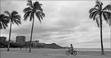  ??  ?? Een fietser rijdt langs de lege Waikiki Beach. (Foto: De Telegraaf)
