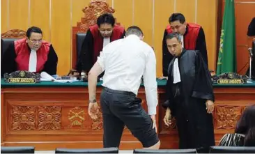  ??  ?? Scarred: Mccartney showing his injuries before a panel of Indonesian judges during the trial of Umar Patek in Jakarta yesterday. — AFP