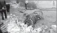  ?? AP/Ibaa News Agency ?? A section of engine from a downed Russian fighter jet sits in a street in Syria’s Idlib province on Saturday. Militants linked to al-Qaida claimed credit. The pilot was said to have been killed when he resisted capture after ejecting safely.